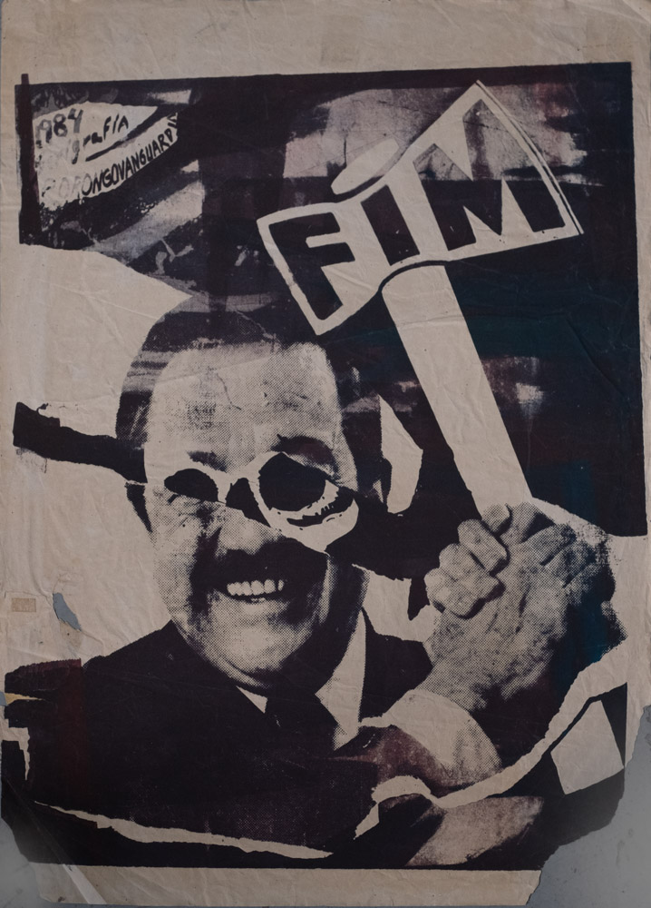 A black and white collage with a smiling man wearing sunglasses and a suit and tie holding a hammer or axe that says FIM on it.