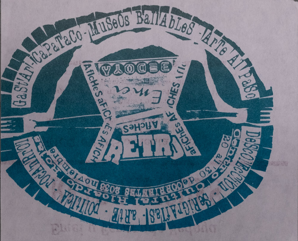 A silk-screened flyer in aqua green ink on grey paper with a horizontally oval image of concentric rings surrounding a green center. Fork-like forms that point outwards from a central ziggurat shape are connected with a river-like shape. Text appears around the edges of the central image within the oval and related to the Museo Baillables events.