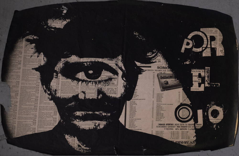 A poster for Por El Ojo. On a piece of newspaper is a silkscreened image of a mustachioed man with messy hair, a single large eye replaces his two eyes and eyebrows. A black area on the right of the image reads "Por El Ojo" in large bold letters.